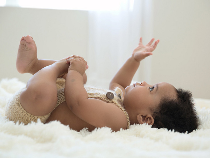 8 month baby boy portrait, laying on a soft blanket, backlit with natural window light.  MN photographer Kari Layland